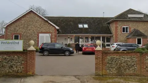 Google Brick-built care home with two 2-storey wings connected by single-storey glazed corridor.