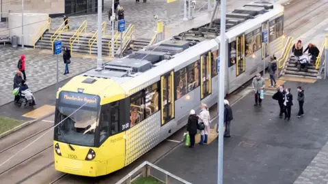 TFGM Metrolink tram at stop