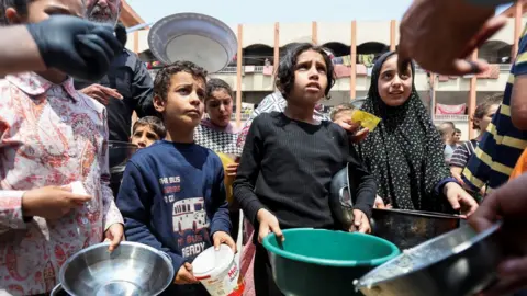 Palestinians gather to receive food meals cooked by World Central Kitchen
