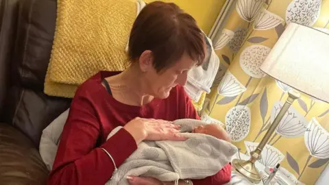 Emma Madden Julie Stocks holds her grandson after he was born