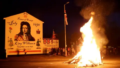 PAcemaker A bonfire burning in front of a William of Orange Mural