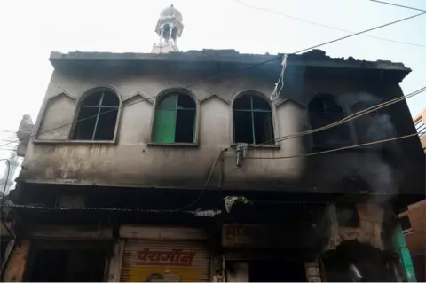 AFP burnt-out mosque and shops are seen following clashes between people supporting and opposing a contentious amendment to India"s citizenship law, in New Delhi on February 26, 2020.