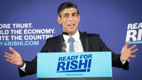 PA Media Rishi Sunak seen on stage at the launch of his campaign to be Conservative Party leader at the Queen Elizabeth II Centre in London