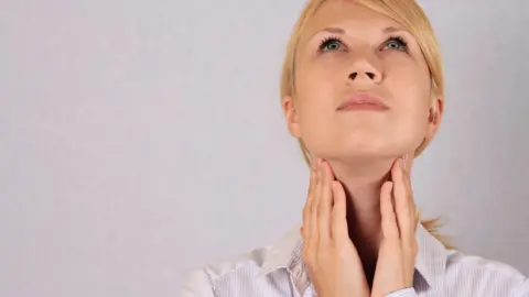 Getty Images woman touching her neck