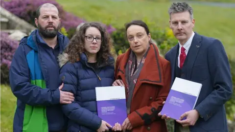 PA Media Colin and Kayleigh Griffiths, Rhiannon Davies and Richard Stanton with a copy of the report