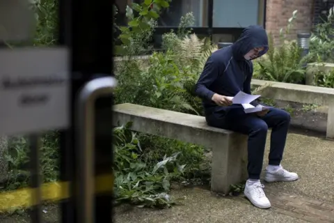 Getty Images Boy on bench with results papers
