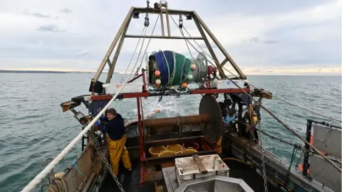 Getty Images Newhaven fishing boat skipper Neil Whitney prepares his boat for the first trawl of the day, off the south-east coast of England