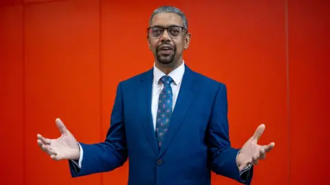 Getty Images CARDIFF, WALES - MARCH 16: Vaughan Gething poses for a portrait after he is announced as the fifth First Minister of Wales at the Cardiff University Spark building on March 16, 2024 in Cardiff, Wales. Mark Drakeford was the fourth First Minister of Wales appointed in December 2018, following Alun Michael, Rhodri Morgan and Carwyn Jones. Vaughan Gething and Jeremy Miles have been competing to replace Mark Drakeford, who officially stands down next week. (Photo by Matthew Horwood/Getty Images)