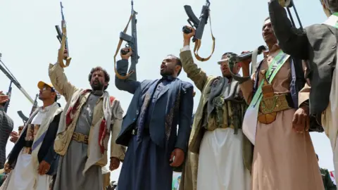 Reuters Mourners hold up their rifles as they attend a mass funeral in Saada, Yemen on 13 August 2018.