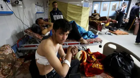 Reuters Palestinians wounded in a rush on an aid convoy rest on beds at Al-Shifa hospital in Gaza