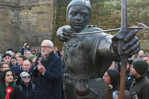 Joe Giddens / PA Media Jeremy Corbyn next to a statue of Robin Hood