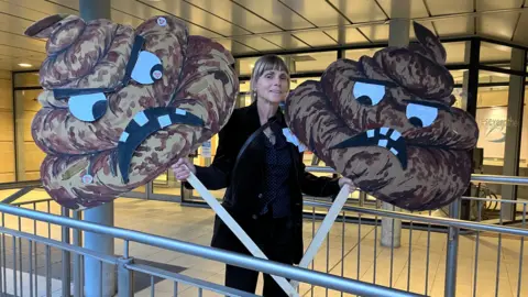 BBC Woman with poo emoji signs