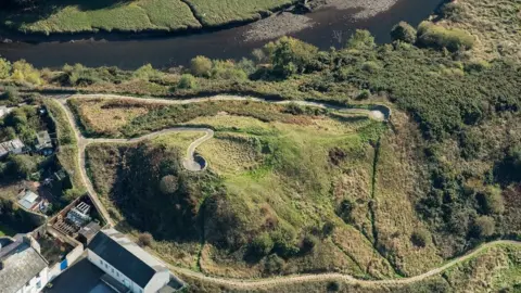 Historic England Aerial view of hill with paths and fortification remains