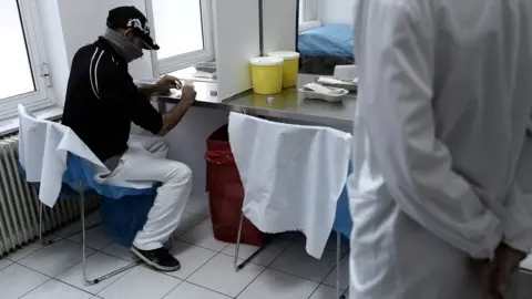 Getty Images A man using drugs while a medic watches