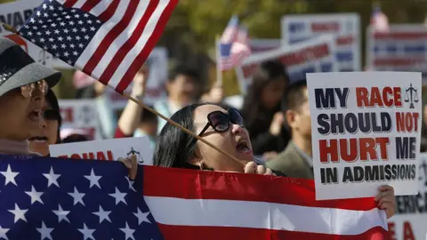 Getty Images A woman cheers at a rally in Boston's Copley Square to support Students for Fair Admissions' lawsuit against Harvard University, 14 October 2018