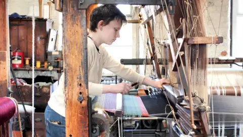 Bea Uprichard weaving on the restored loom