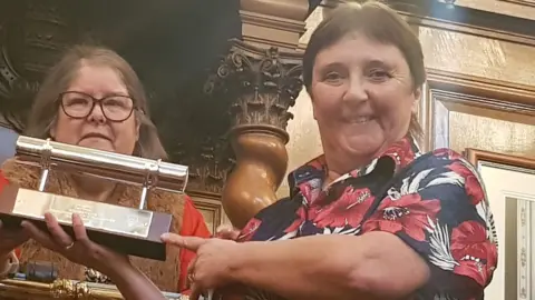 Carol Thomas Carol Thomas being presented a trophy