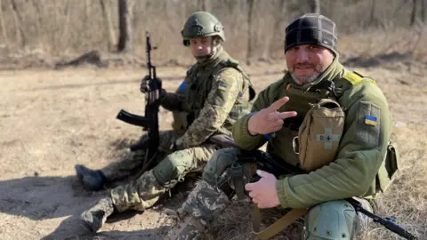 Orla Guerin / BBC Recruits rest on the ground during their combat training