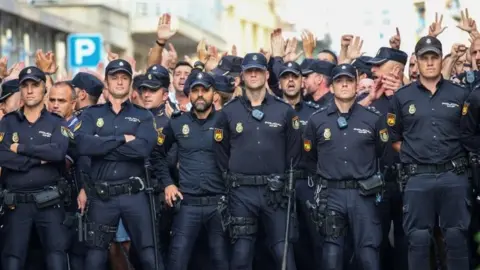 Reuters Spanish National Police officers stand outside their hotel as they face locals protesting against their presence in Pineda de Mar, north of Barcelona (03 October 2017)