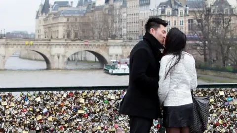 Getty Images young couple kiss on a bridge