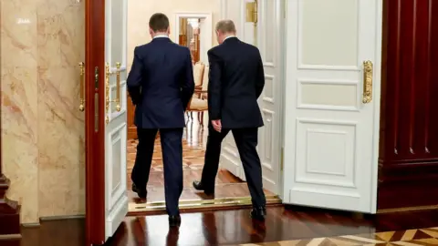 EPA Russian President Vladimir Putin (R, back to camera) and Russian Prime Minister Dmitry Medvedev (L, back to camera) leave after a meeting with Cabinet members at Government headquarters in Moscow, Russia, 15 January 2020