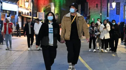Getty Images Two people walk down High Street wearing face masks in Cardiff