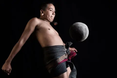 AFP Ricardo Campos, a player of the pre-Columbian ballgame Ulama, hits a solid rubber ball with his hip