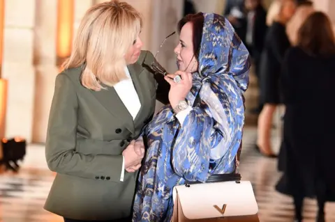 AFP French first lady Brigitte Macron (L) greets her Mauritanian counterpart Tekber Mint Melainine Ould Ahmed at Versailles Palace, France - Sunday 11 November 2018