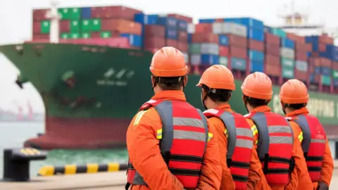 Getty Images Men stand on a port in China