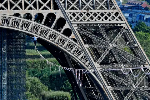 ALAIN JOCARD / AFP French highliner Nathan Paulin performs on a 70-metre-high slackline in Paris.