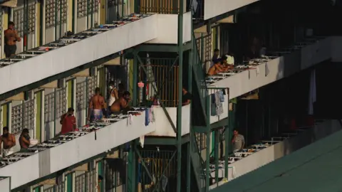 Reuters Migrant workers are pictured standing outside their dormitory rooms at Cochrane Lodge II