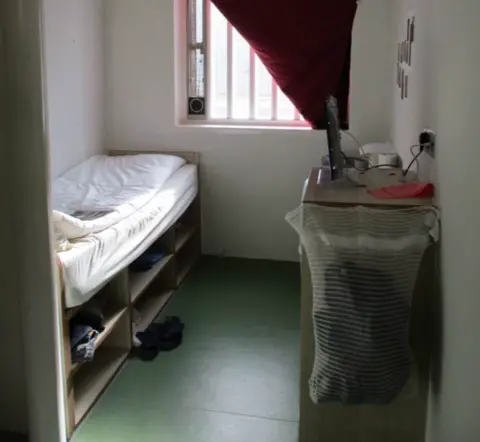 HM Inspectorate of Prisons A prison cell with a single bed and bars on the windows