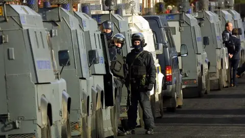 Getty Images/Adrian Dennis The large police convoy waiting to protect the Holy Cross school run in 2001