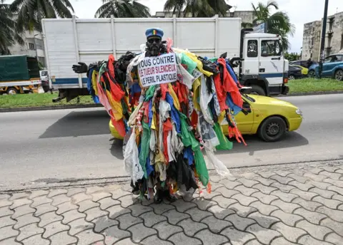 Sia Kambou/ AFP A man posing in the street dressed in plastic waste - 5 June.