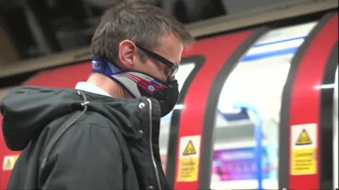 BBC Man wearing a dust mask on Tube