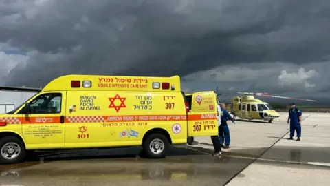 Magen David Adom ambulance service Yellow ambulance with helicopter in the background