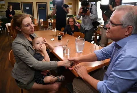 EPA Scott Morrison meets a woman in child in Picton, New South Wales, in front of media representatives