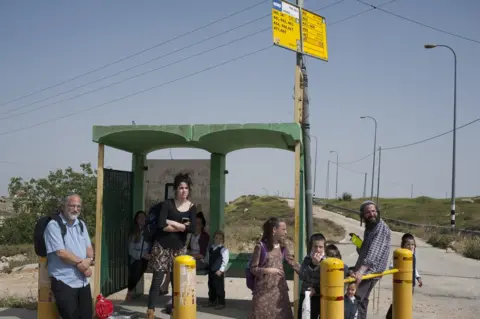 Geraldine Hope Ghelli Hitchhikers standing by a road in the West Bank