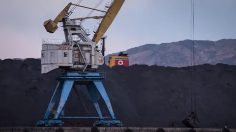 Getty Images North Korean coal -- which would once have been bound for China -- is piled up on one side of the barrier in Rajin harbour, stranded by a UN ban on coal exports by Pyongyang