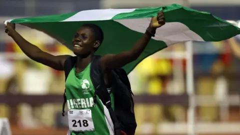 Jamie Squire/Getty Woman holding Nigerian flag, 7 August 2023