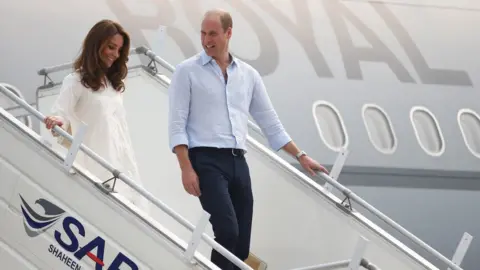 PA Media Duke and Duchess of Cambridge walk down the steps of a plane as they arrive in Lahore on 17 October 2019