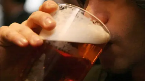 PA Media Man drinking beer - stock image