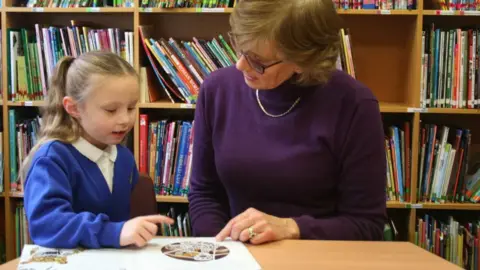 Schoolreaders child reading to a woman