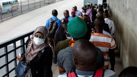 AFP People walk on a pedestrian bridge in Dar es Salaam, Tanzania - 16 April 2020