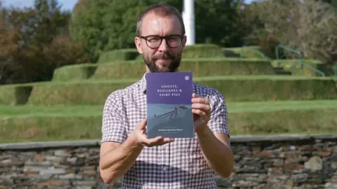 CULTURE VANNIN James Franklin holding a copy of the book