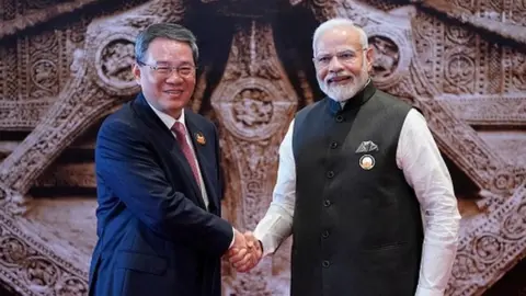 India's Prime Minister Narendra Modi (R) shakes hand with Chinese Premier Li Qiang ahead of the G20 Leaders' Summit in New Delhi on September 9, 2023.