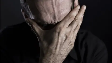 Getty Images man with head in hands