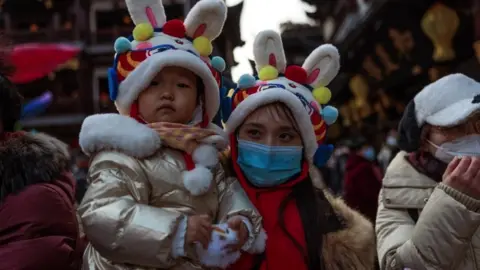 EPA A woman with a child wearing a bunny hat