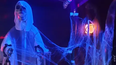 Gary and Lesley decorate their front garden with ghosts and cobwebs