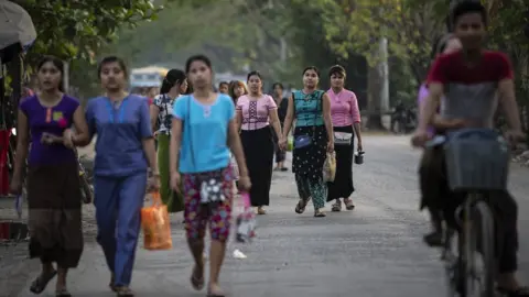 Getty Images Women workers leave a factory outside Yangon, Myanmar